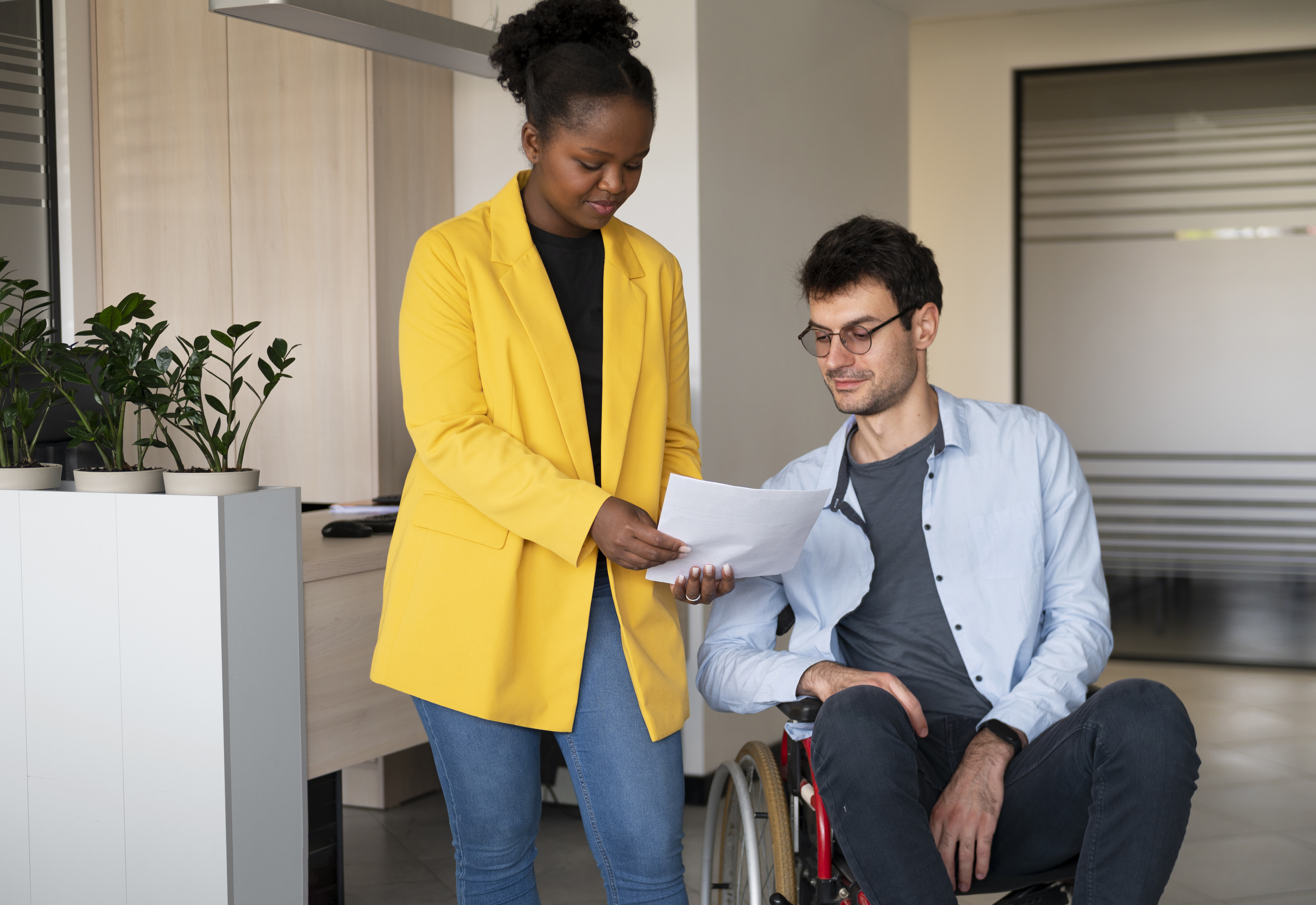 Support worker assisting a person in a wheelchair in a professional setting